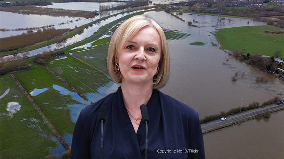 UK prime minister Liz Truss stands in front of flooded land in the UK
