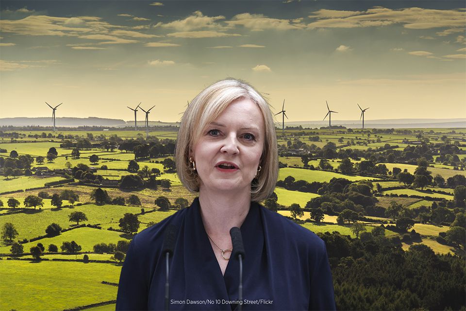 UK prime minister Liz Truss stands in front of an aerial view of wind turbines and farmland near Leeds
