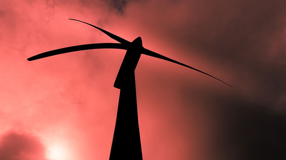 Wind turbine against a red hot background