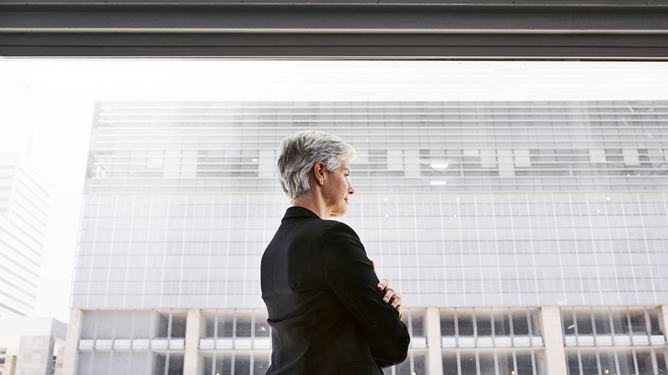 Shot of a confident mature businesswoman looking thoughtfully out of a window in a convention centre