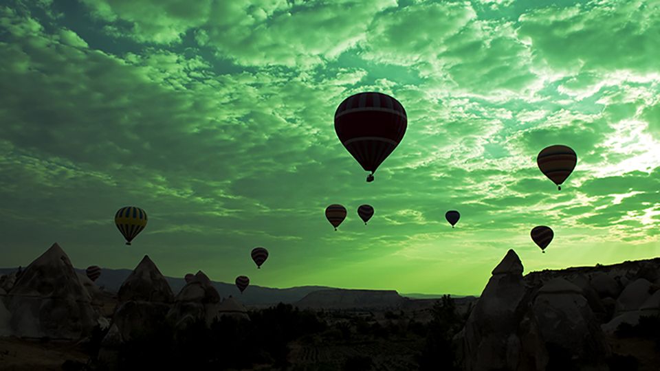 Green Hot Air Balloons flying on the sky of mysterious Cappadocia