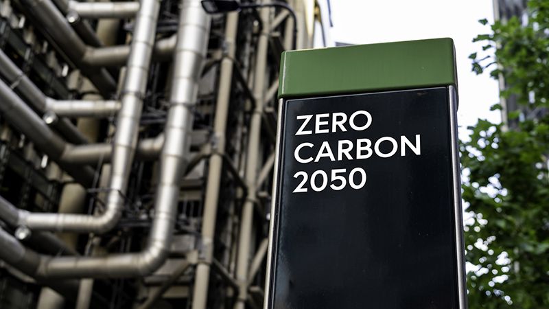 Zero Carbon 2050 on a sign in front of an Industrial building