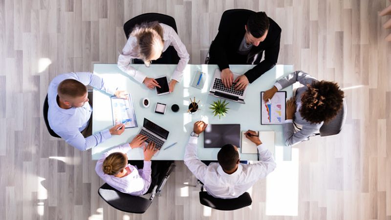 Elevated View Of Businesspeople Working On Graphs In Office