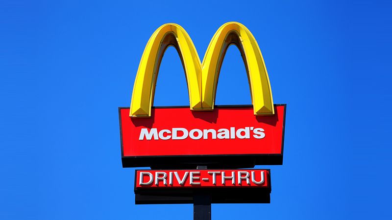 London, United Kingdom, May 27, 2012 : McDonald's yellow and red drive-thru logo advertising sign placed on a pole with a clear blue sky