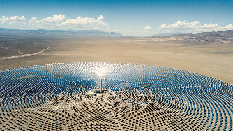 Aerial view from a drone down to large solar thermal power station in the dry desert landscape to the horizon. Nevada, USA.