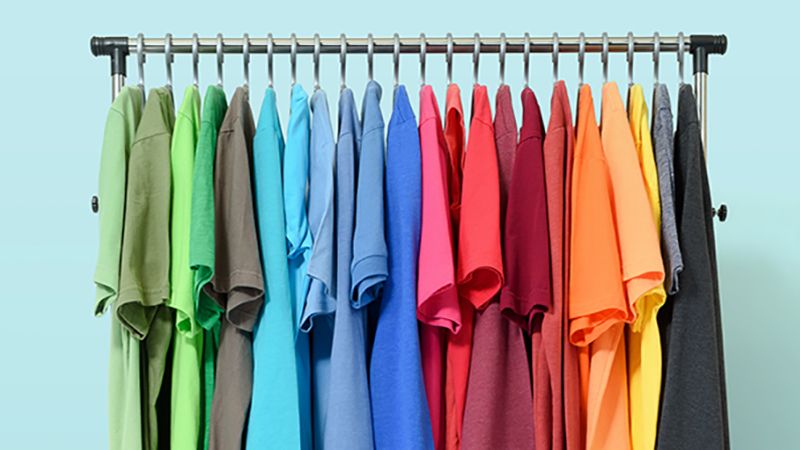 Mobile rack with color clothes on light blue background