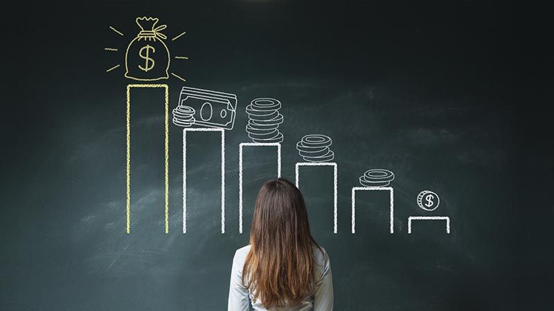 Business woman standing in front of a blackboard with a financial chart