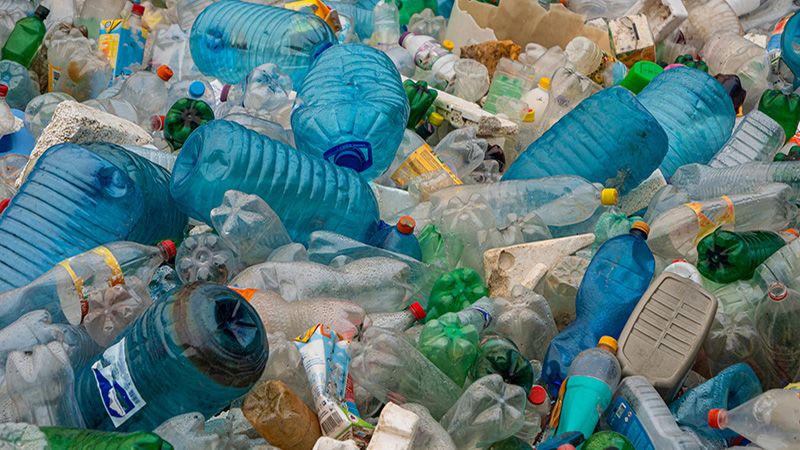 TIRANA, ALBANIA, MARCH 2022: Accumulated pile of empty plastic bottles, styrofoam and tetra packs. Sad view of littering and environmental damage. Urgent need to establish efficient waste management.