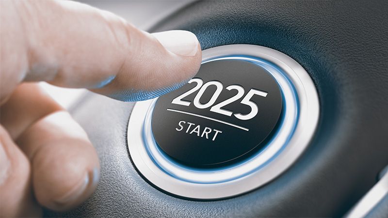 Finger pressing a car ignition button with the text 2025 start. Year two thousand and twenty five concept. Composite image between a hand photography and a 3D background.