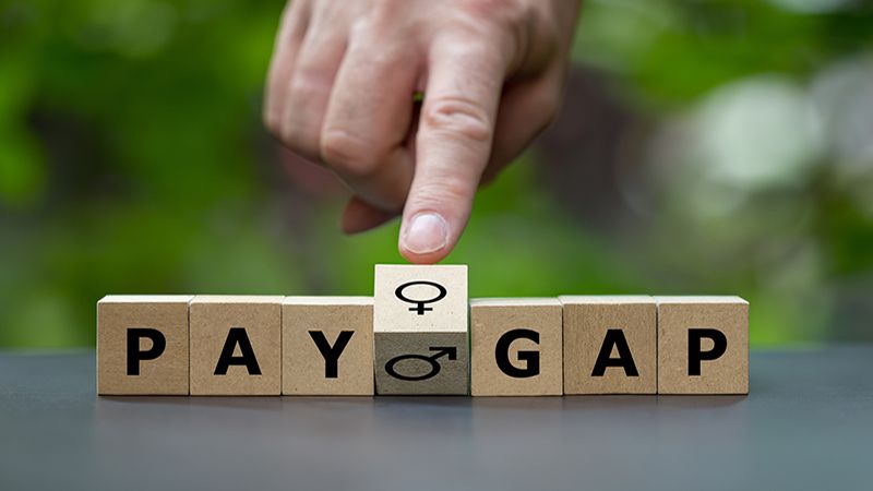 Wooden cubes form the expression 'pay gap'.