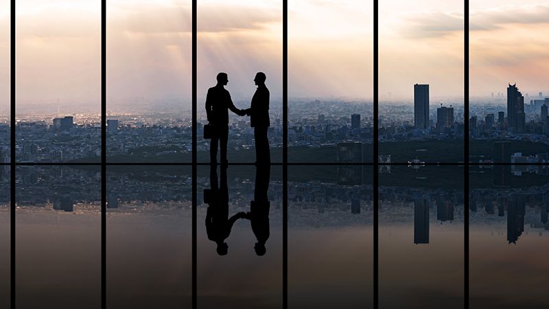 Businesspeople in front of urban cityscape.