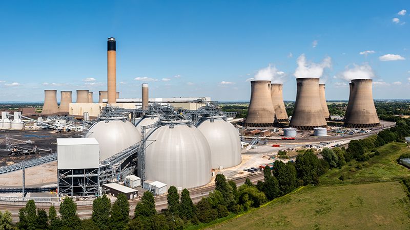 Aerial landscape view of a large coal fired power plant with storage tanks for Biofuel burning instead of coal