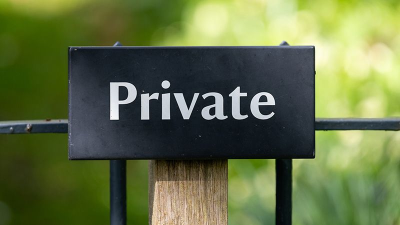 Close up of a wooden sign that says private