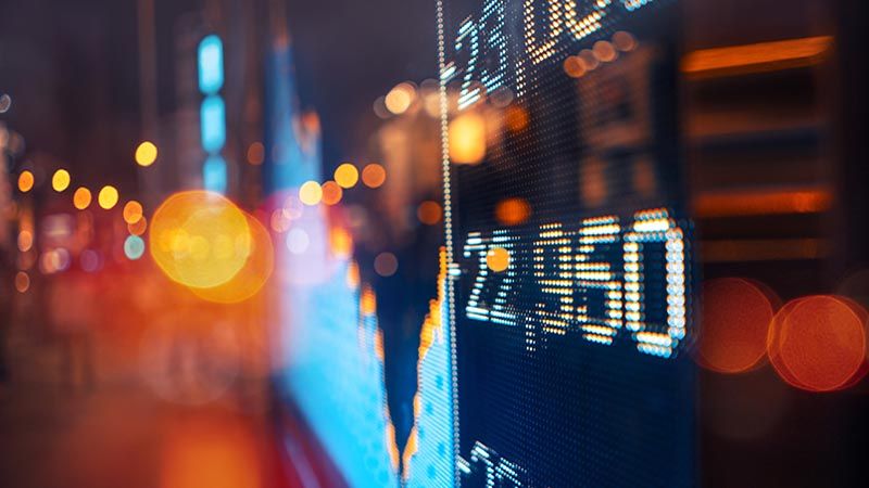 Digital Stock Market Display in an Urban Setting at Twilight